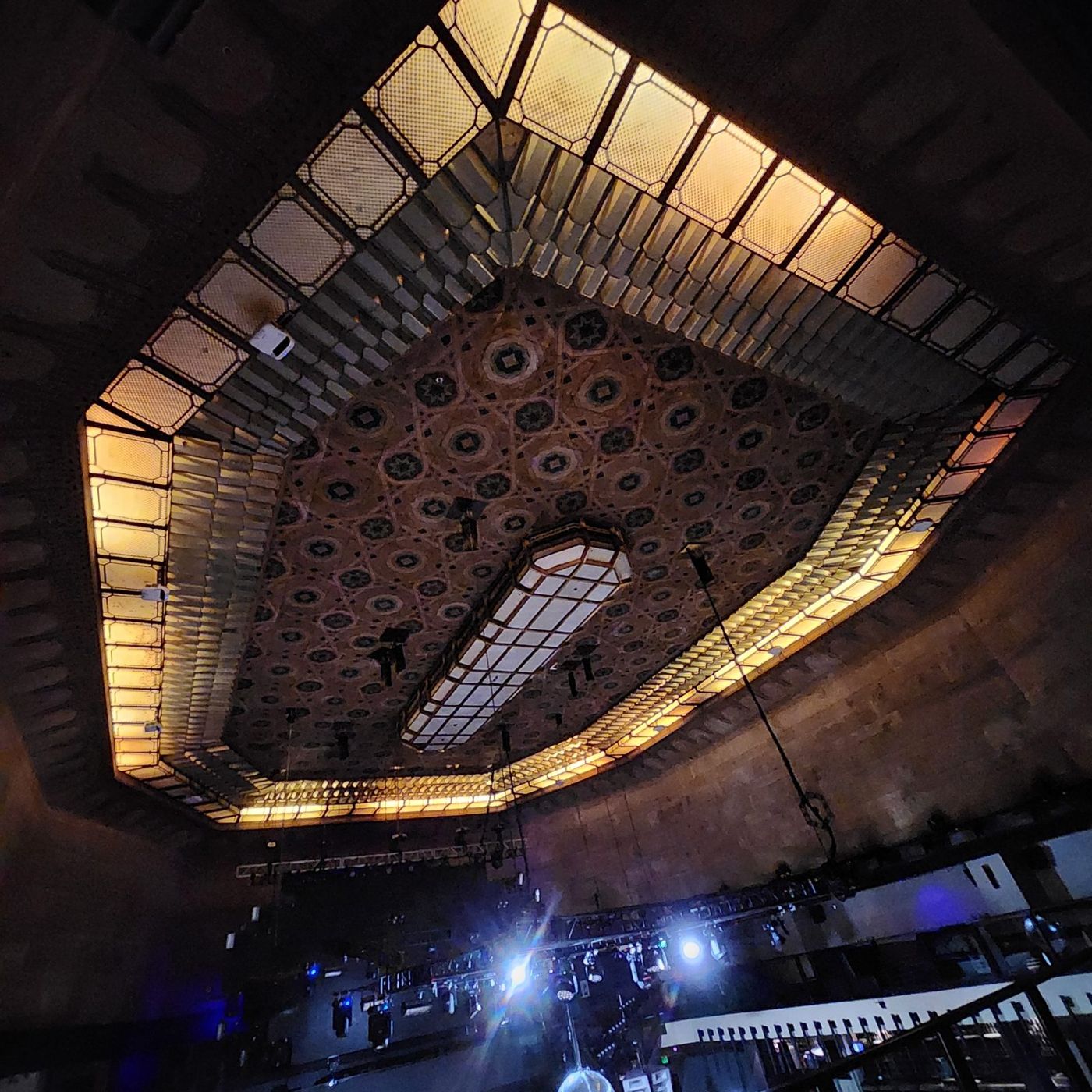 Looking up at the ornate historic ceiling with lighting rigs below it